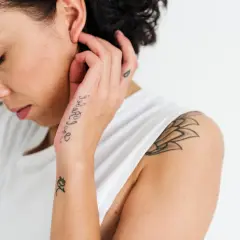 Frau mit Schriftzug-Tattoo auf dem Handrücken. Ein Mann würde sich über dieses hand tattoo schrift freuen.