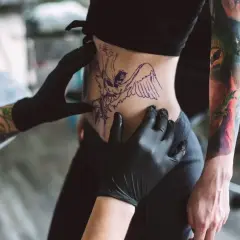 Tätowierer bereitet Motiv vor. Nach dem Stechen ist die Frage: wie lange tattoo mit Bepanthen eincremen?