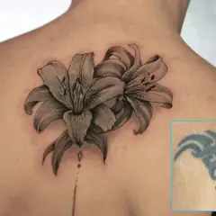 Ein Mann hat ein altes Tribal-Tattoo am Oberarm mit zwei realistischen Lilien überdeckt.