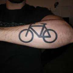 Schwarzes Fahrrad-Tattoo auf einem behaarten Arm. Ein Symbol für die Liebe zum Radfahren nach dem Tattoo.