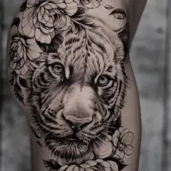 Ein beeindruckendes **ganzer Arm Tattoo Frau**: ein realistischer Tigerkopf umrahmt von üppigen Blumen und Blättern.