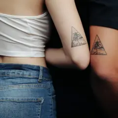 Zwei Arme mit passenden Dreiecks-Tattoos, die Palmen und eine Hängematte zeigen. Eine schöne Tattoo Idee Familie, die Verbundenheit symbolisiert.