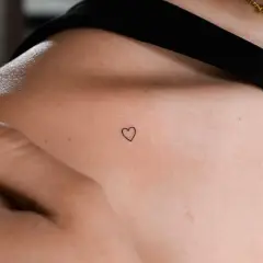 Kleines Herz-Freundschaftstattoo auf der Schulter einer Frau, ein zartes Symbol ewiger Verbundenheit.