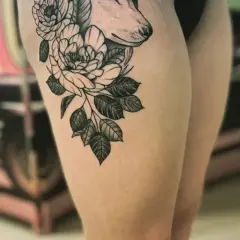 Ein Wolfskopf mit Blumen auf dem Oberschenkel. Die Folie ist ab, bereit für die Heilung.
