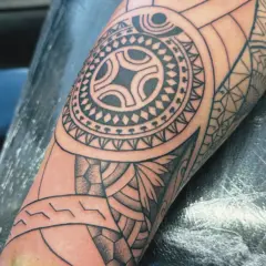 Ein detailliertes Maori-Tattoo auf dem Arm, das die Verbundenheit der Familie symbolisiert.