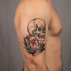Ein Tattoo mit einem Totenkopf und einer Sanduhr, ein Symbol für die Vergänglichkeit des Lebens.