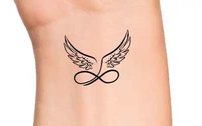 Ein zartes Engel Tattoo mit Schriftzug und Unendlichkeitszeichen auf dem Handgelenk.