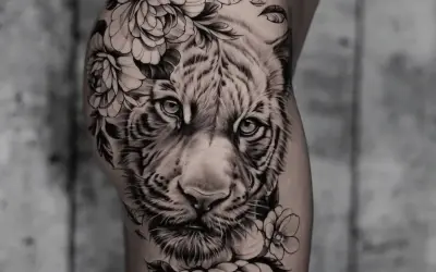 Ein beeindruckendes **ganzer Arm Tattoo Frau**: ein realistischer Tigerkopf umrahmt von üppigen Blumen und Blättern.