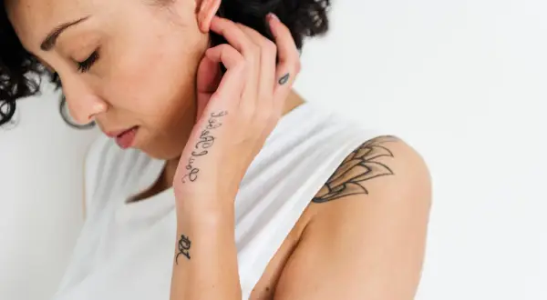 Frau mit Schriftzug-Tattoo auf dem Handrücken. Ein Mann würde sich über dieses hand tattoo schrift freuen.