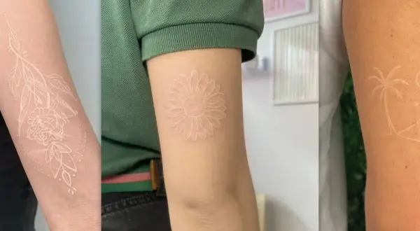 Drei Arme mit filigranen weißen Tattoos: eine Rose mit Blättern, eine Gänseblümchen und eine Palme.