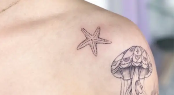 Kleines Seestern-Tattoo auf der Brust, neben einer Qualle.