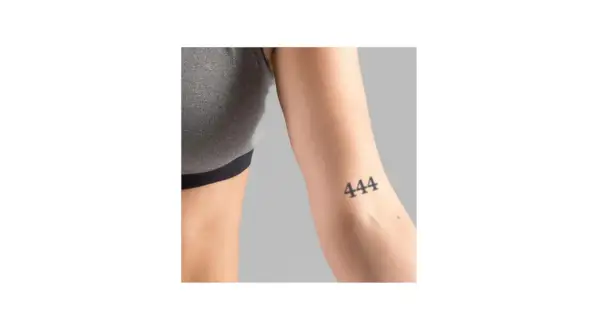 Ein Unterarm mit einem Tattoo der Zahl 444. Dieses engelszahlen tattoo bedeutungsvolle Symbol steht für Schutz und göttliche Führung.