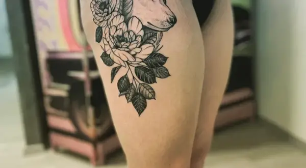 Ein Wolfskopf mit Blumen auf dem Oberschenkel. Die Folie ist ab, bereit für die Heilung.