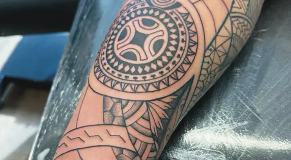 Ein detailliertes Maori-Tattoo auf dem Arm, das die Verbundenheit der Familie symbolisiert.