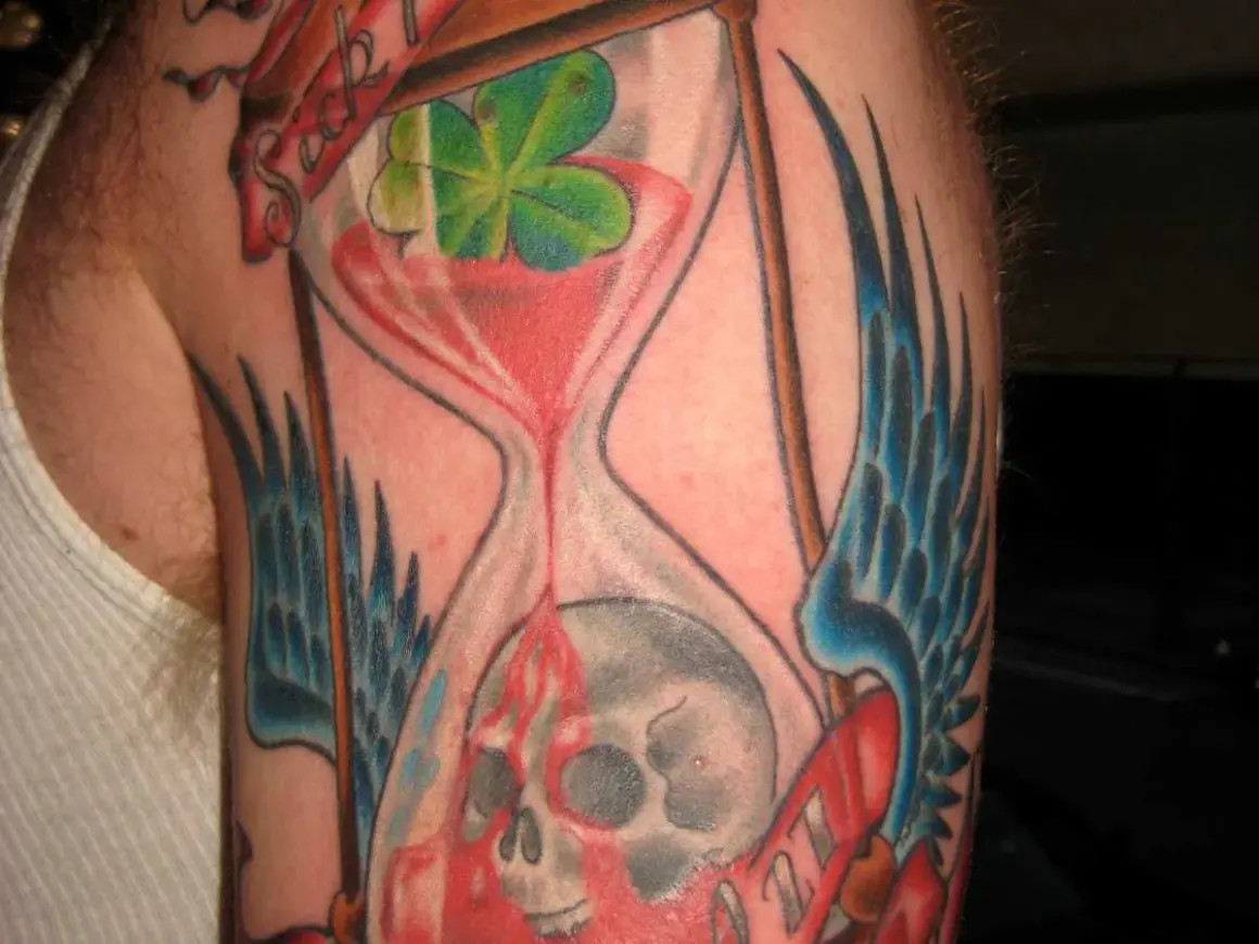 Ein **tattoo sanduhr zerbrochen**, die Zeit fließt unaufhaltsam, symbolisiert Vergänglichkeit und Neuanfang.