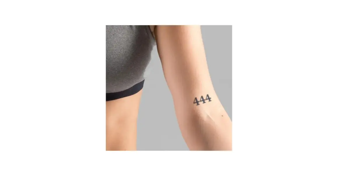 Ein Unterarm mit einem Tattoo der Zahl 444. Dieses engelszahlen tattoo bedeutungsvolle Symbol steht für Schutz und göttliche Führung.