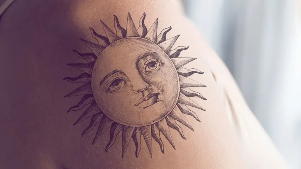Ein detailreiches Tattoo einer Sonne mit menschlichem Gesicht und Strahlen auf der Haut. Dieses sonnenstrahlen tattoo strahlt Wärme aus.