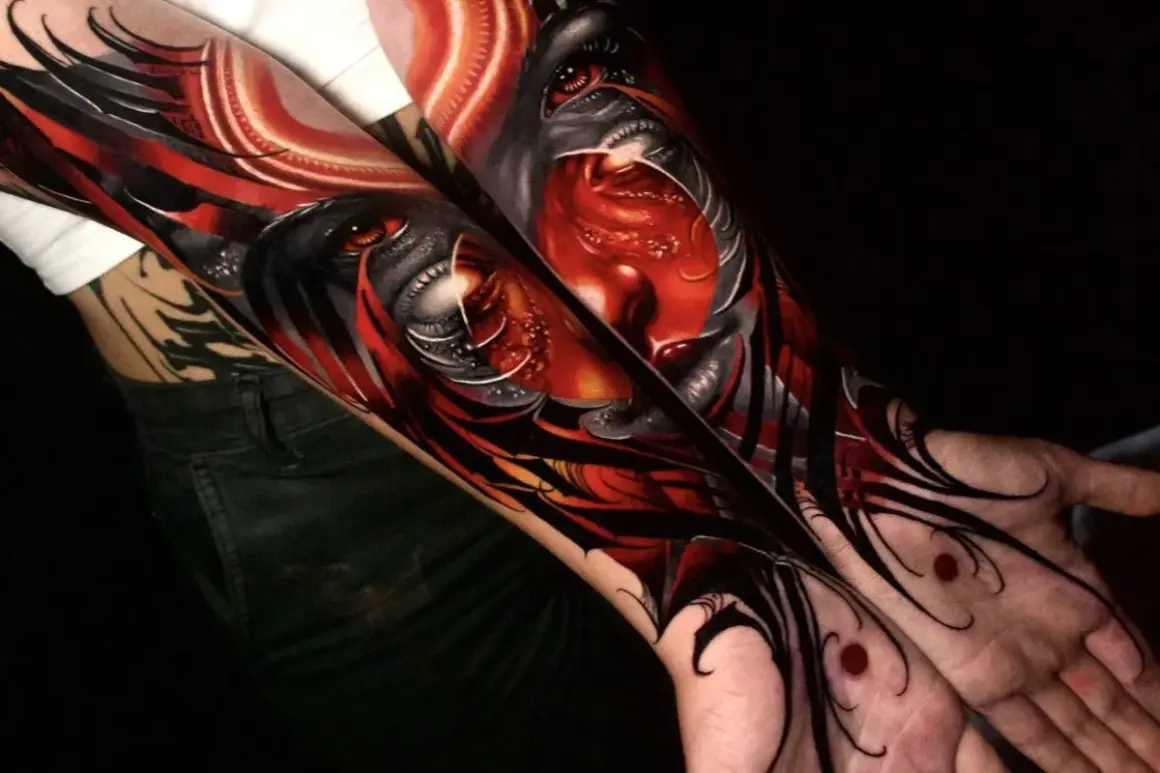 Arm-Tattoos mit roten Tattoos, die ein dämonisches Gesicht mit roten Augen und scharfen Zähnen darstellen.