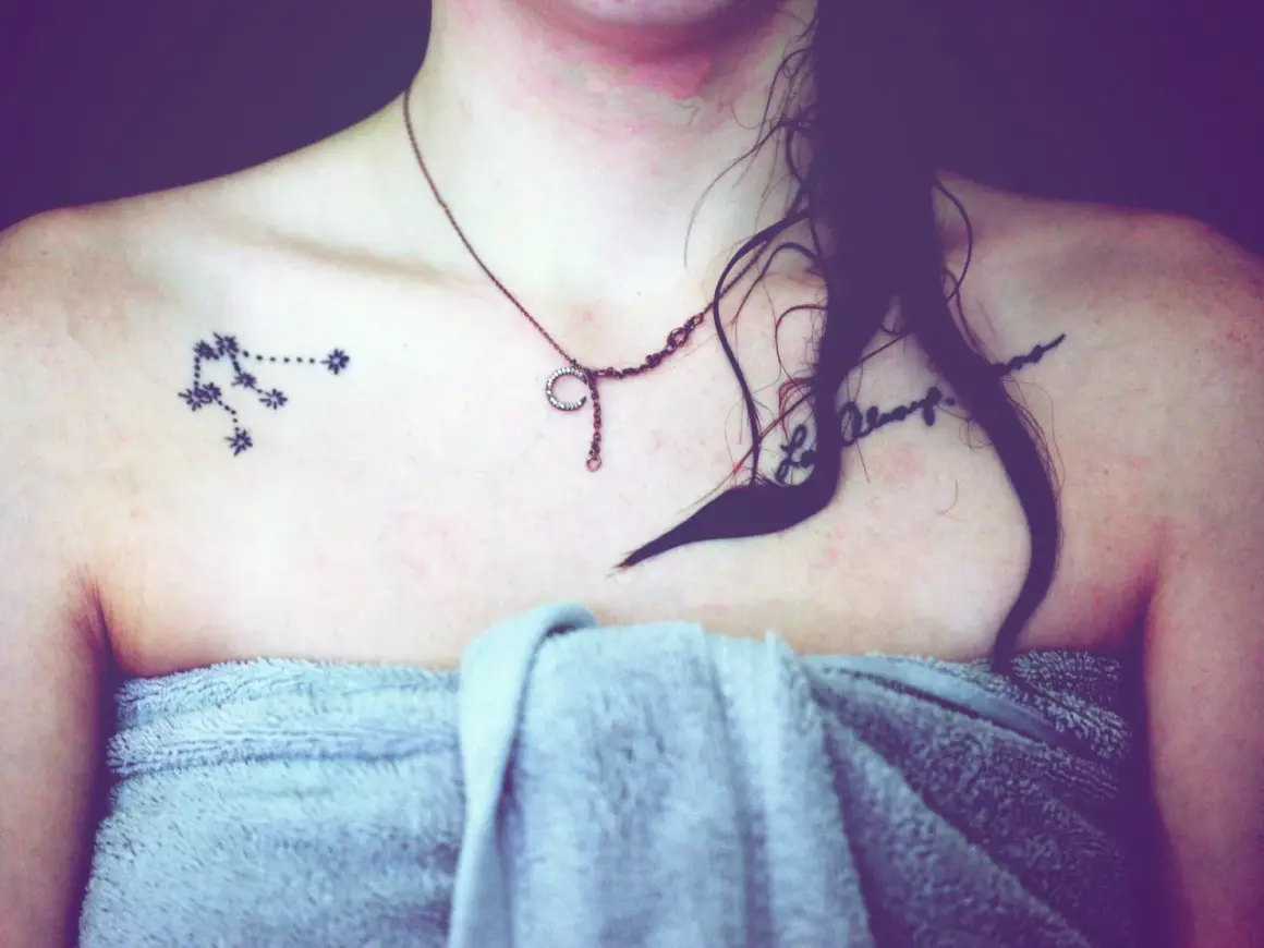 Tattoo eines Sternbilds auf der Schulter einer Frau mit einer Kette und einem Handtuch.