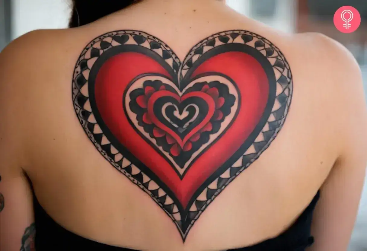 Gro&szlig;es, detailreiches Herz-Tattoo in Schwarz und Rot auf dem R&uuml;cken.