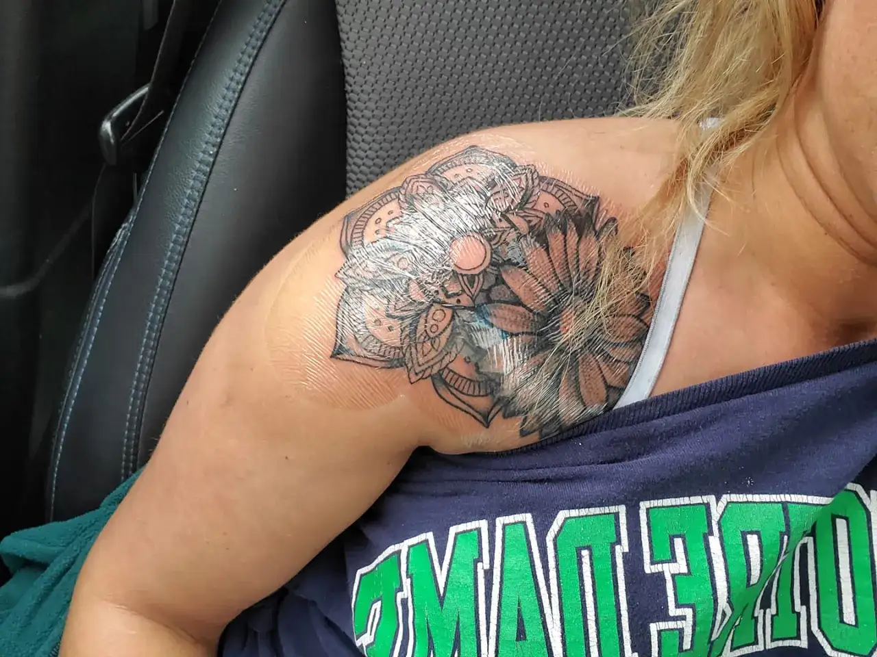 Ein neues silberhaut tattoo, ein Mandala-Design, bedeckt die Schulter einer Frau.