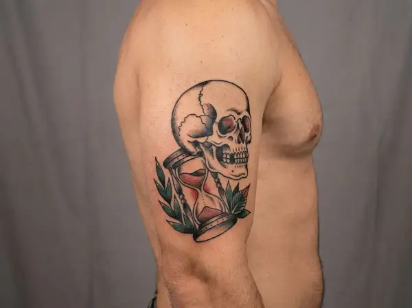 Ein Tattoo mit einem Totenkopf und einer Sanduhr, ein Symbol für die Vergänglichkeit des Lebens.