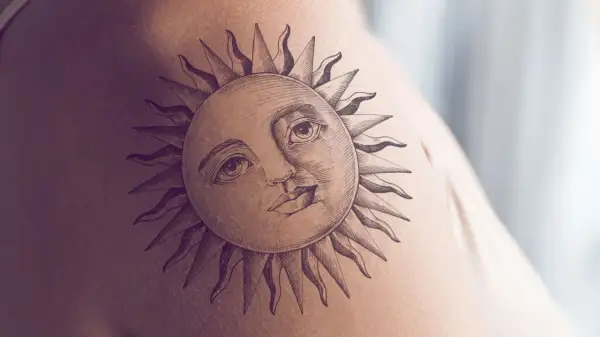 Ein detailreiches Tattoo einer Sonne mit menschlichem Gesicht und Strahlen auf der Haut. Dieses sonnenstrahlen tattoo strahlt Wärme aus.