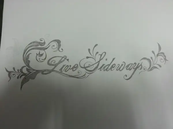 Eine Skizze für ein Tattoo mit geschwungener Schrift: "Live Sideways", umgeben von floralen Ornamenten.